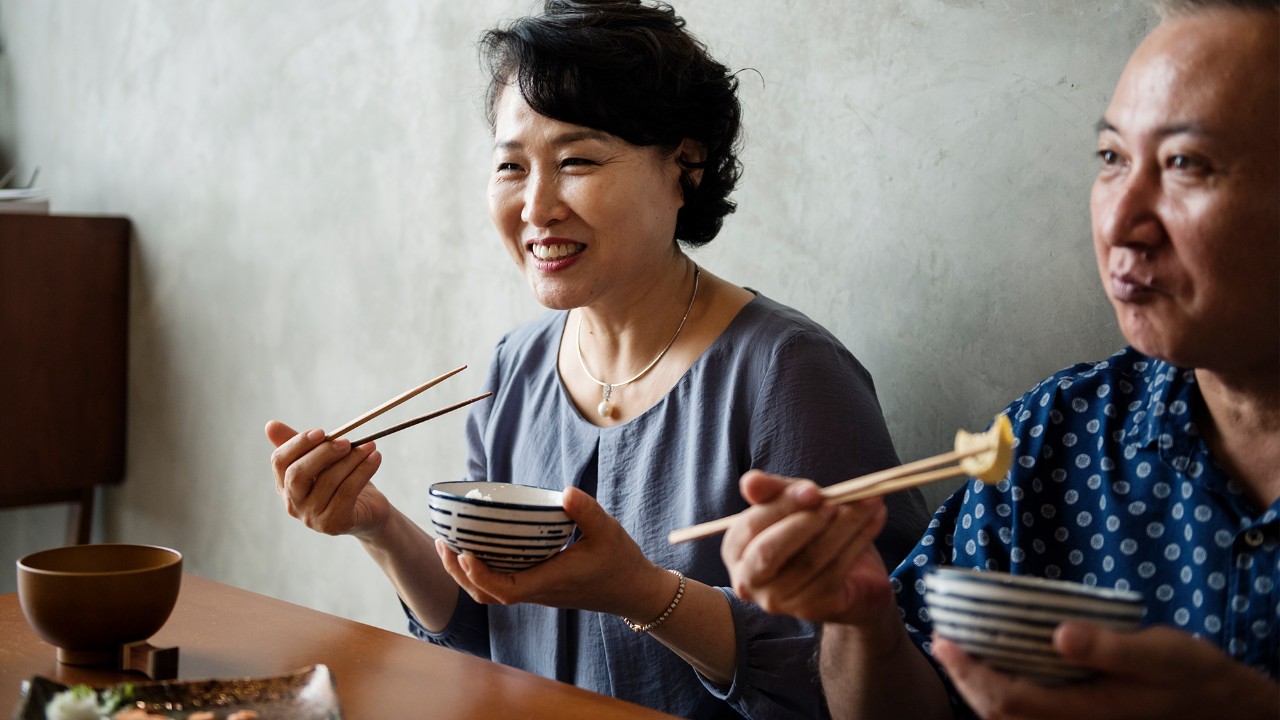Asian couple eating a bowl; image used for HSBC Macau Offers page