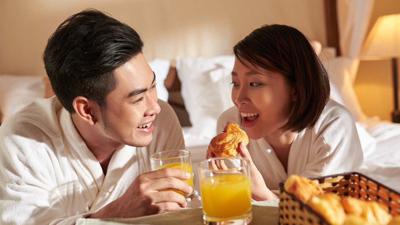 Asian couple having breakfast on bed; image used for HSBC Macau Offers page