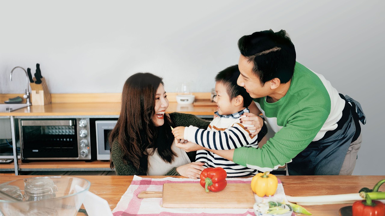 幸福的一家人在廚房吃飯；圖片用於澳門匯豐滙盛人生保險計劃