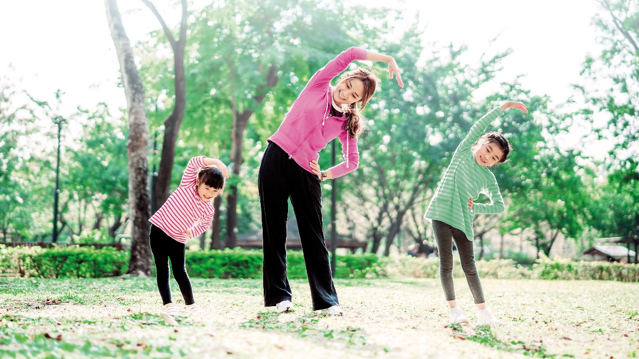 A mother and her children are doing exercise in the park; image used for HSBC Macau HSBC Flexi Medical Insurance Plan page.