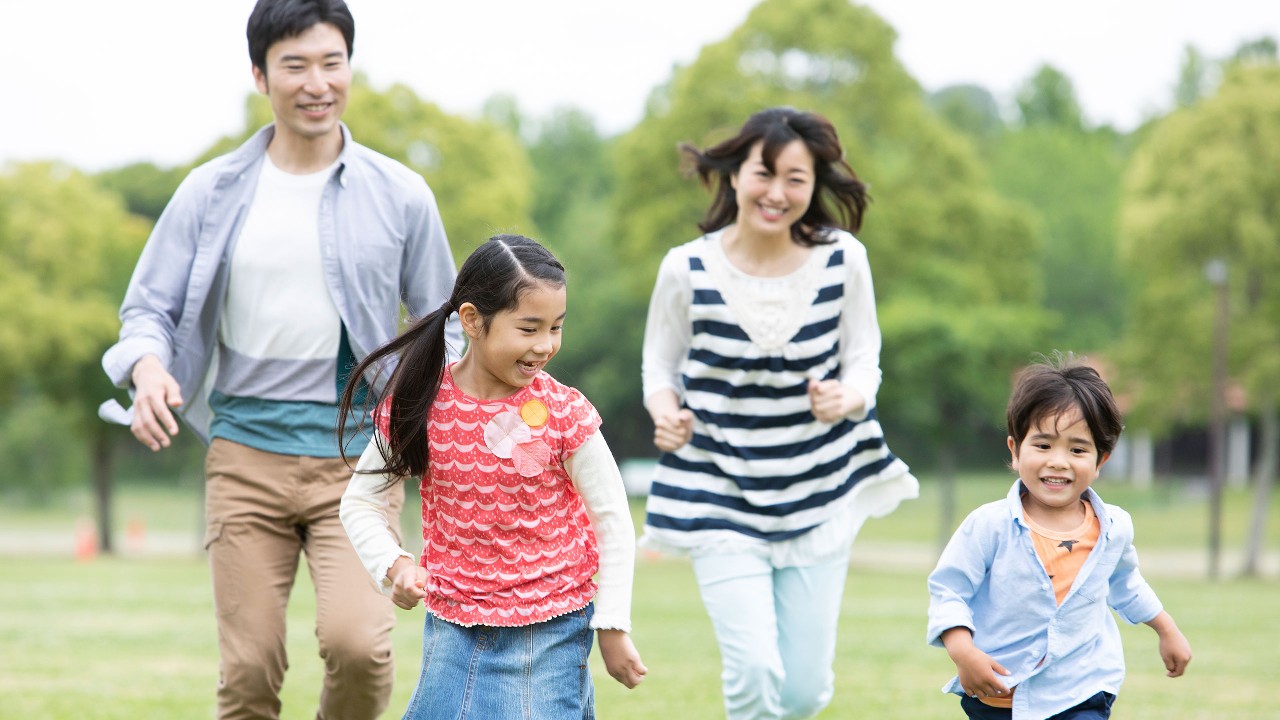 一家人在草坪上奔跑; 圖片使用於關於滙豐保險「豐富產品組合」。